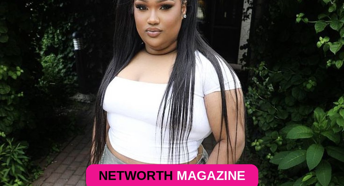Biggie outside in a white top and jeans